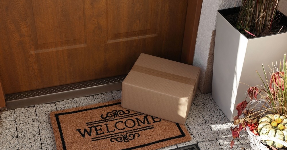 A delivered box waiting on the doormat at a front door